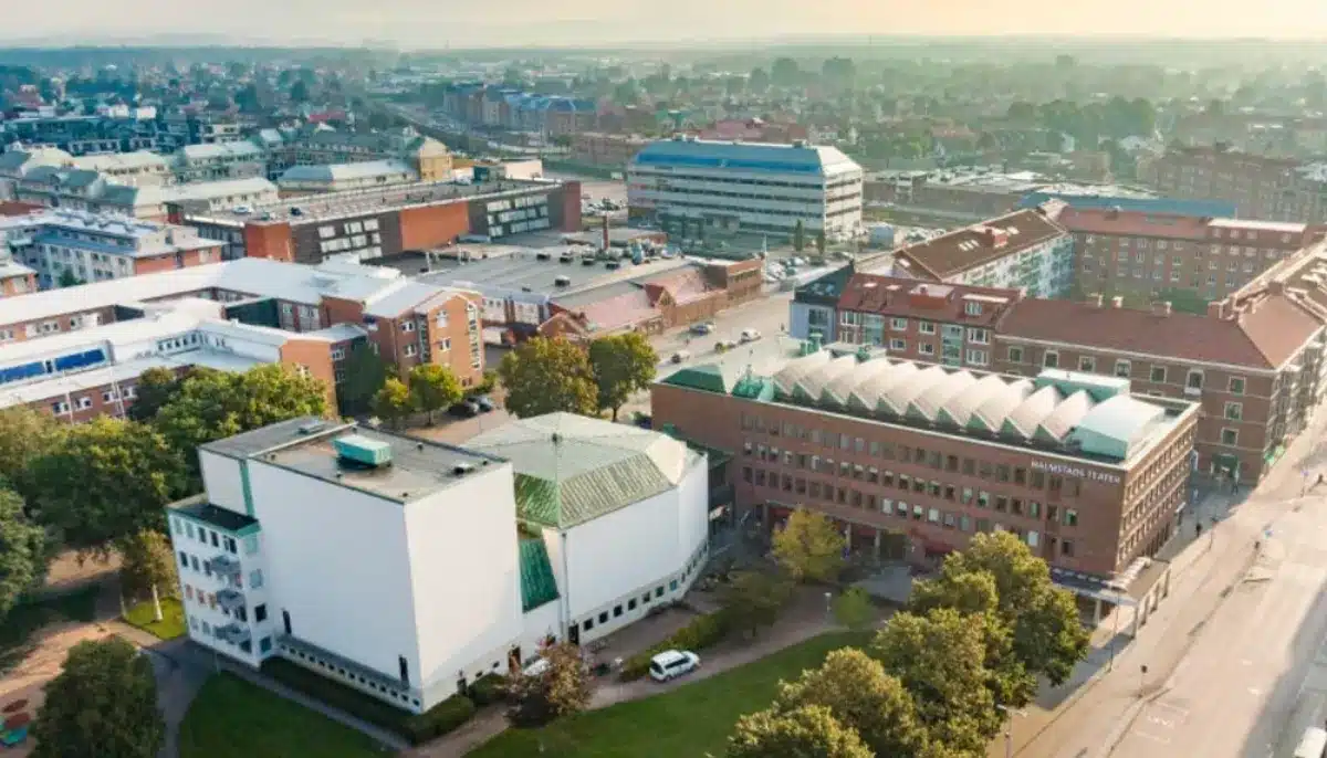 Flygfoto över centrala Halmstad med Halmstads Teater och omgivande byggnader i morgonljus.